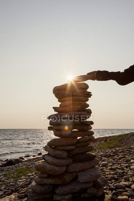Boy putting last stone onto stone heap — Stock Photo