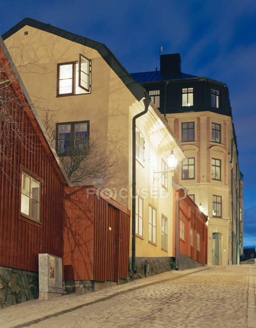 Häuser mit beleuchteten Fenstern nachts auf der Straße — Stockfoto