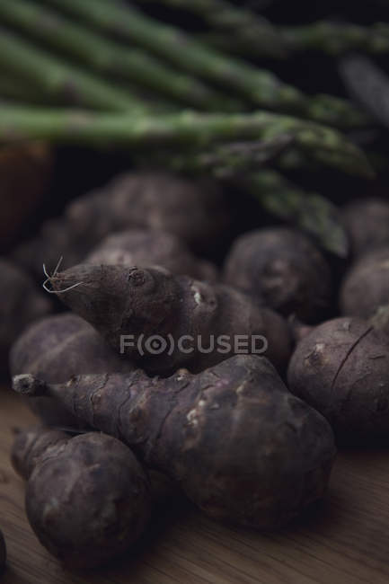 Close-up of jerusalem artichoke and asparagus on table — Stock Photo