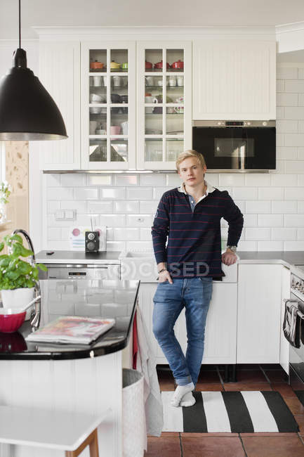 Portrait of teenage boy in domestic kitchen — Stock Photo