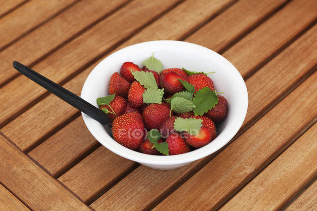 Fresh picked strawberries with leaves in bowl — Stock Photo