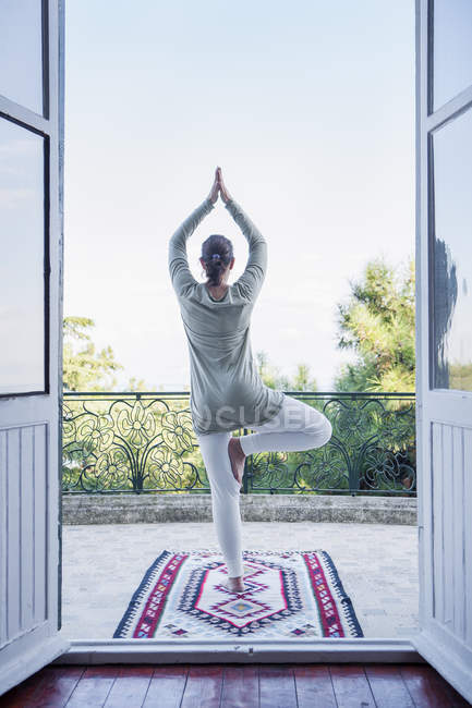 Rear view of mature woman doing yoga — Stock Photo