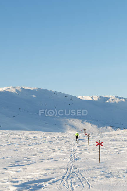 Чоловік перетинає гірські лижі взимку — стокове фото