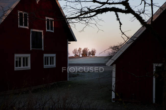 Case residenziali e campo smerigliato al tramonto — Foto stock