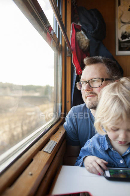 Father and daughter traveling by train, differential focus — Stock Photo