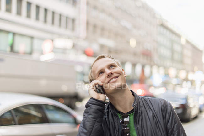 Mittlerer erwachsener Mann, der auf dem Smartphone spricht, selektiver Fokus — Stockfoto