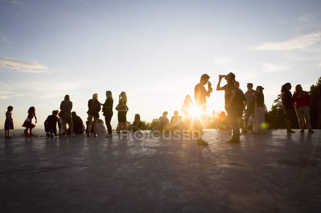 Young people spending time at music festival during sunset — Stock Photo