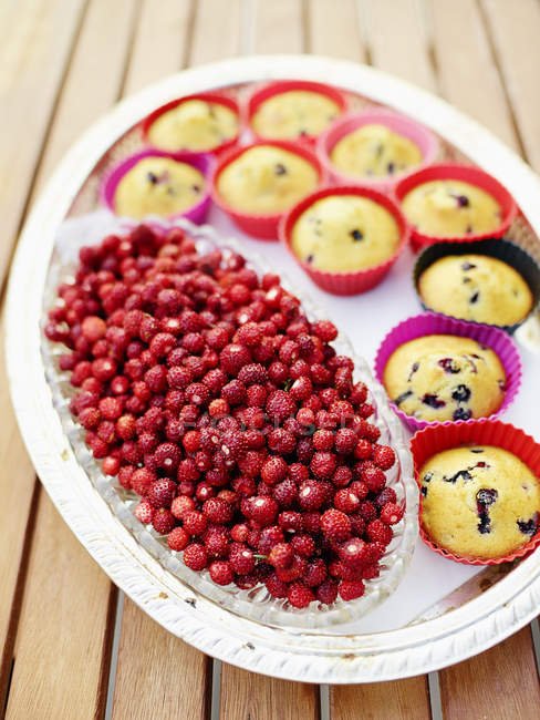 Still life of muffins and wild strawberries on tray — Stock Photo
