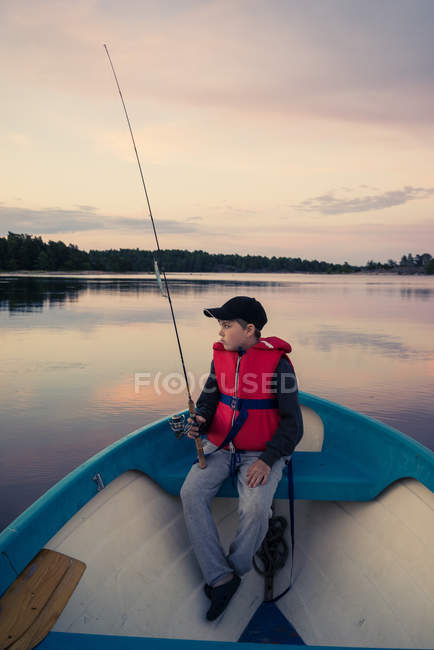 Garçon voler pêche en bateau sur le lac — Photo de stock