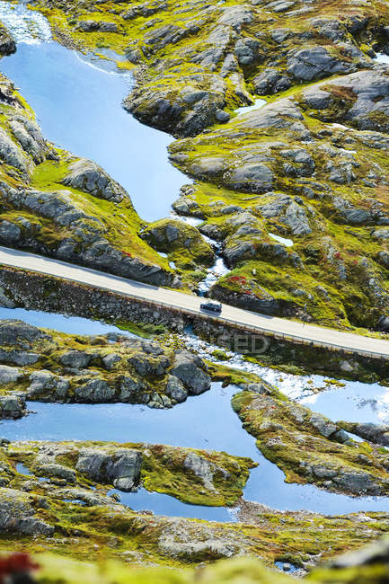 Auto cavalcando attraverso sole illuminato valle allagata montagna — Foto stock