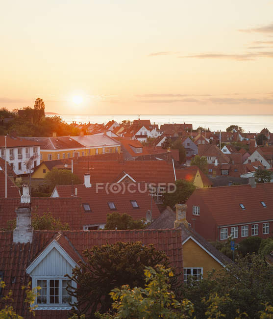 Міські будівлі дахи з морем на сонячному світлі — стокове фото