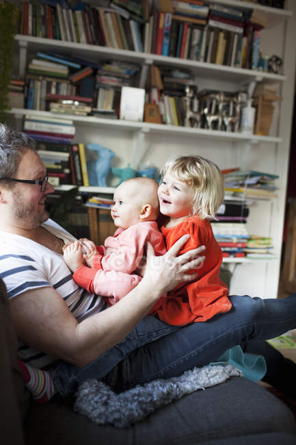 Padre giocare con figlie in camera domestica — Foto stock