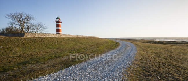 Вид на сільську дорогу і червоний маяк на сонячному світлі — стокове фото