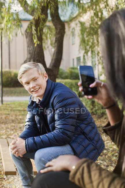 Teenage friends taking pictures in park — Stock Photo