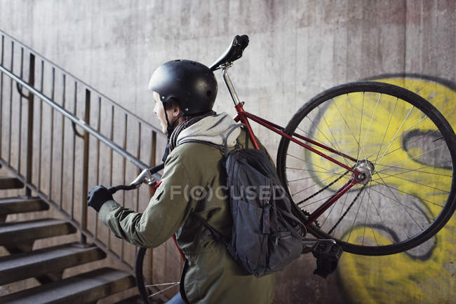 Взрослый мужчина с велосипедом на лестнице — стоковое фото