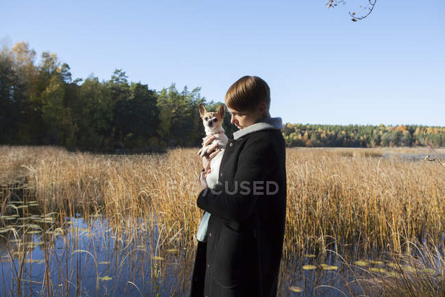 Woman with dog in wetland, focus on foreground — Stock Photo