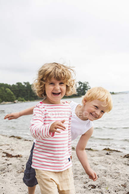Вид спереди девочки и мальчика на пляже — стоковое фото