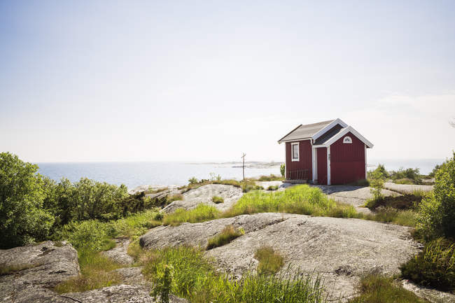 View of red wooden house beside sea — Stock Photo