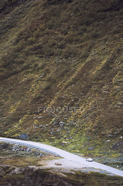 Cars driving along Trollstigen road beside mountain — Stock Photo