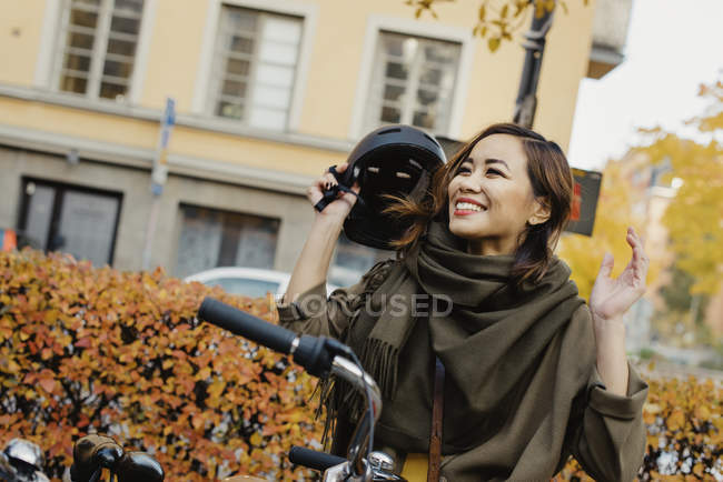 Mujer joven quitándose el casco protector - foto de stock