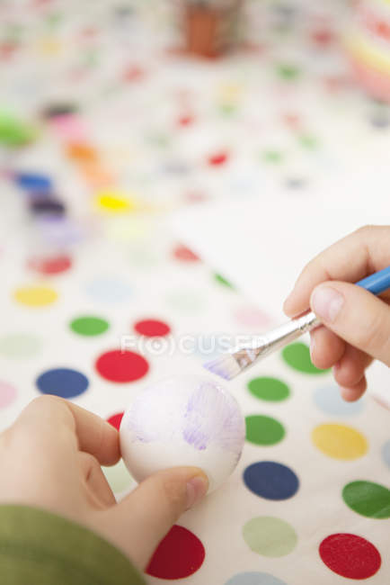 Chica pintando huevo, enfoque selectivo - foto de stock