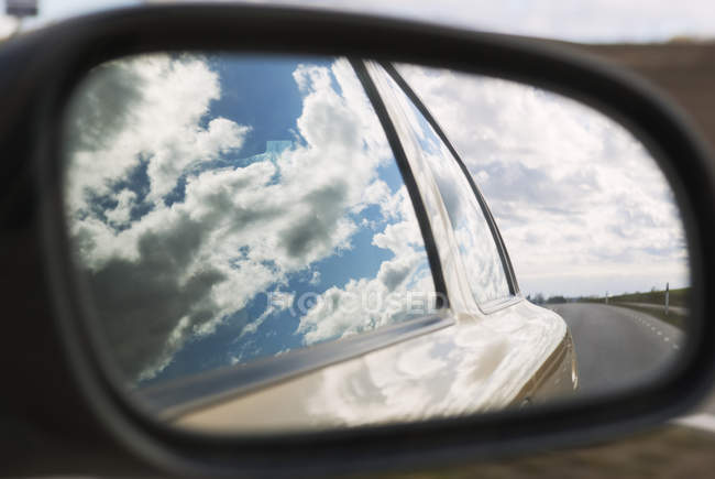 Reflection of cloudy blue sky in car window and mirror — Stock Photo