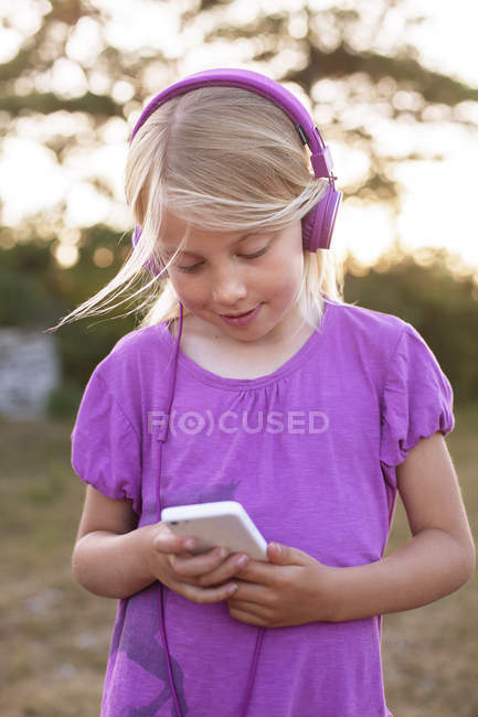 Дівчина слухає музику зі смартфона, вибірковий фокус — стокове фото