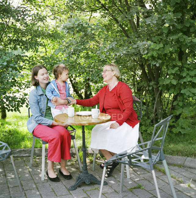 Portrait of mother, grandmother and child in sidewalk cafe — Stock Photo