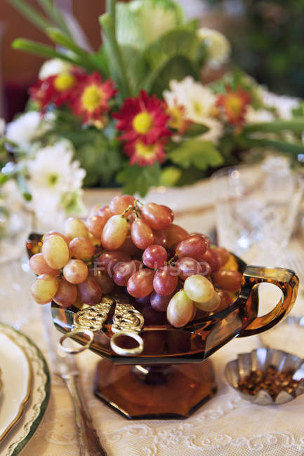Uvas en plato de vidrio en la mesa servida — Stock Photo