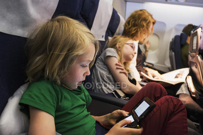 Мать путешествует на самолете с детьми — стоковое фото