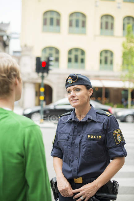 Женщина-полицейский разговаривает с мужчиной на улице, избирательный фокус — стоковое фото