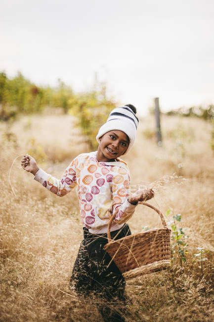 Портрет усміхненої дівчини, що тримає кошик — стокове фото