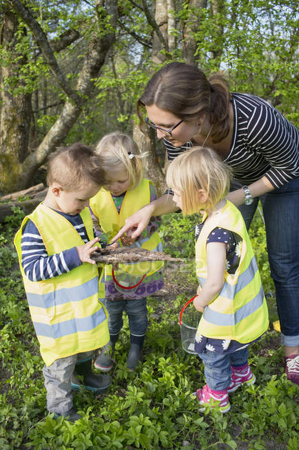 Woman taking care of children outdoors — Stock Photo