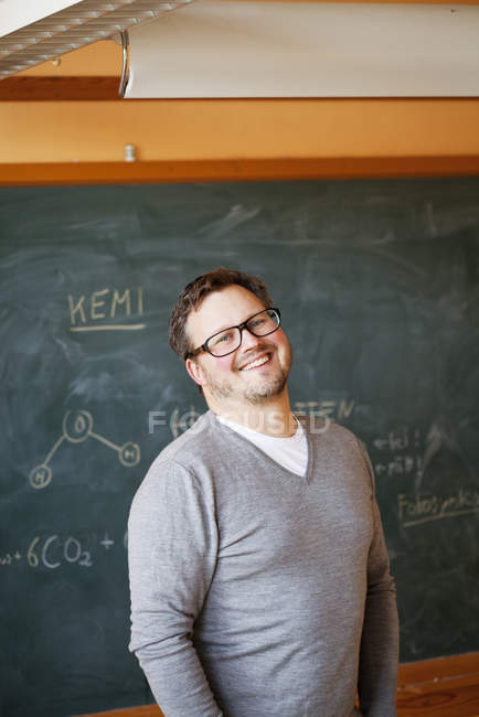 Portrait of teacher in classroom smiling and looking at camera — Stock Photo