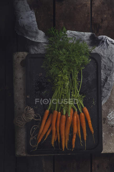 Bouquet de carottes fraîches sur plaque de cuisson — Photo de stock
