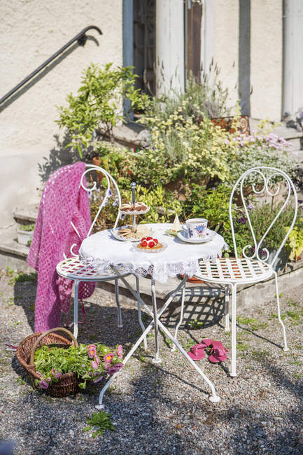 Mesa servida com sobremesas e bebidas e cadeiras no quintal — Fotografia de Stock