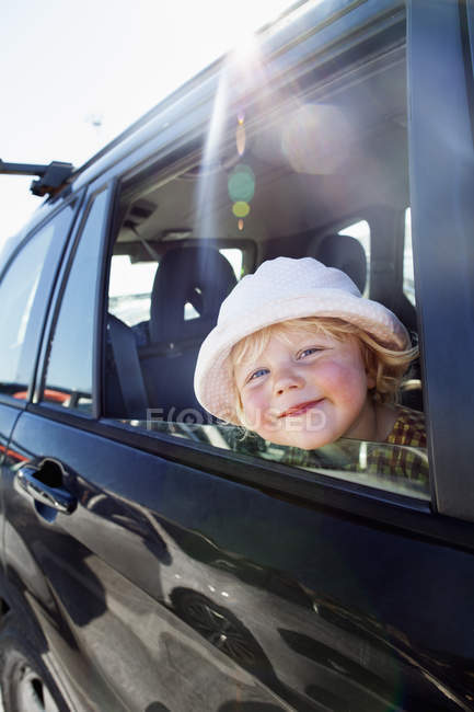 Portrait of girl sitting in car and looking at camera — Stock Photo