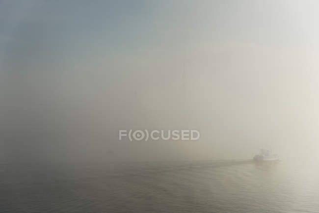 Traghetto che corre su acqua increspata nella nebbia — Foto stock