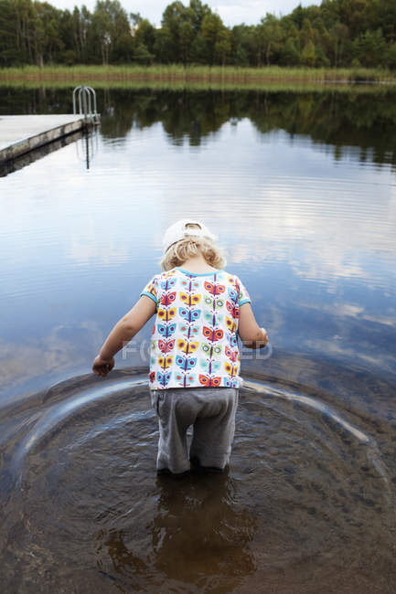 Дівчина стоїть в озері, вид ззаду — стокове фото