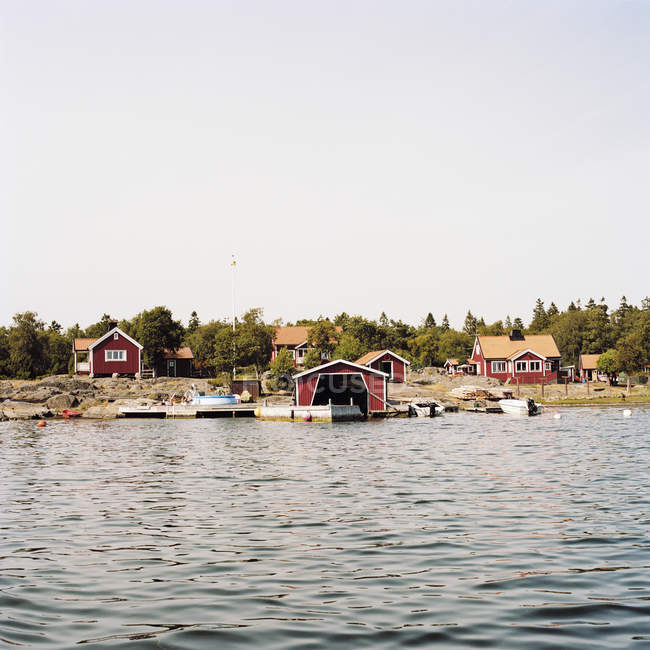 Dorfhafen und falu rote Häuser am Wasser — Stockfoto