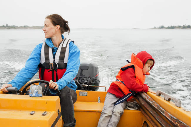 Front view of mother and son on motor boat — Stock Photo