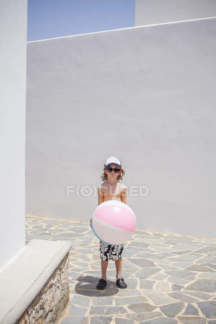 Вид спереди мальчика, стоящего с мячом — стоковое фото