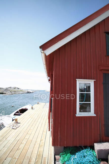 Casa in legno con passerella sul bordo dell'acqua — Foto stock