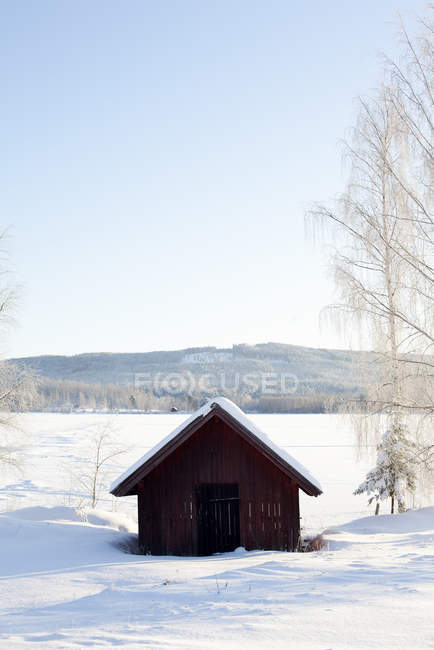 Невеличка дерев'яна хата в зимовий пейзаж — стокове фото
