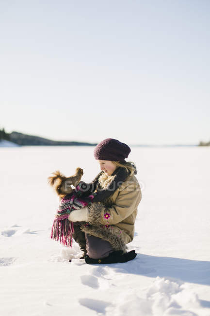 Fille accroupi avec écureuil sur le genou en hiver — Photo de stock