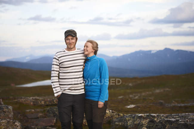 Portrait of couple standing in mountains, focus on foreground — Stock Photo