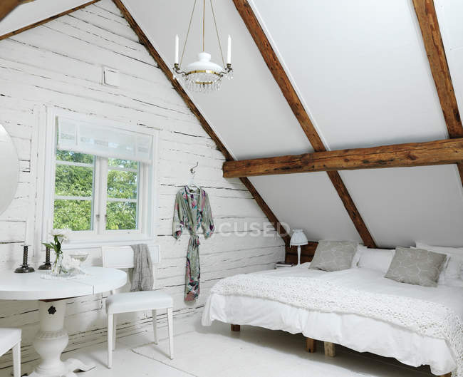 Біла мансардна спальня в сільському стилі — стокове фото