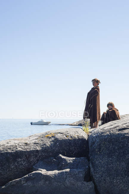 Side view of brothers on rocky seaside — Stock Photo