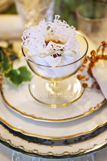 Close up shot of glass with dessert wrapped in lace napkin — Stock Photo