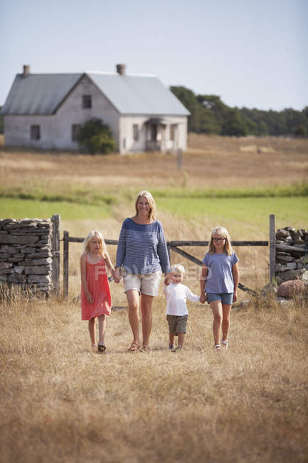 Mother with son and daughters walking in farm yard — Stock Photo